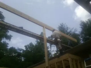 Carpenter setting a ridge beam over a new addition frame — Ice Dam Removal by Roofing Brothers in Belvue