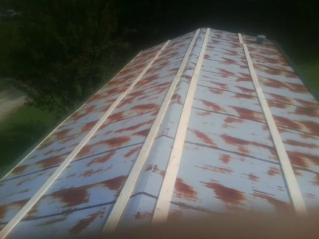 Rusted metal roof panels with new wood purlins before replacement — Storm Damage Roof Repair in Belvue by Roofing Brothers