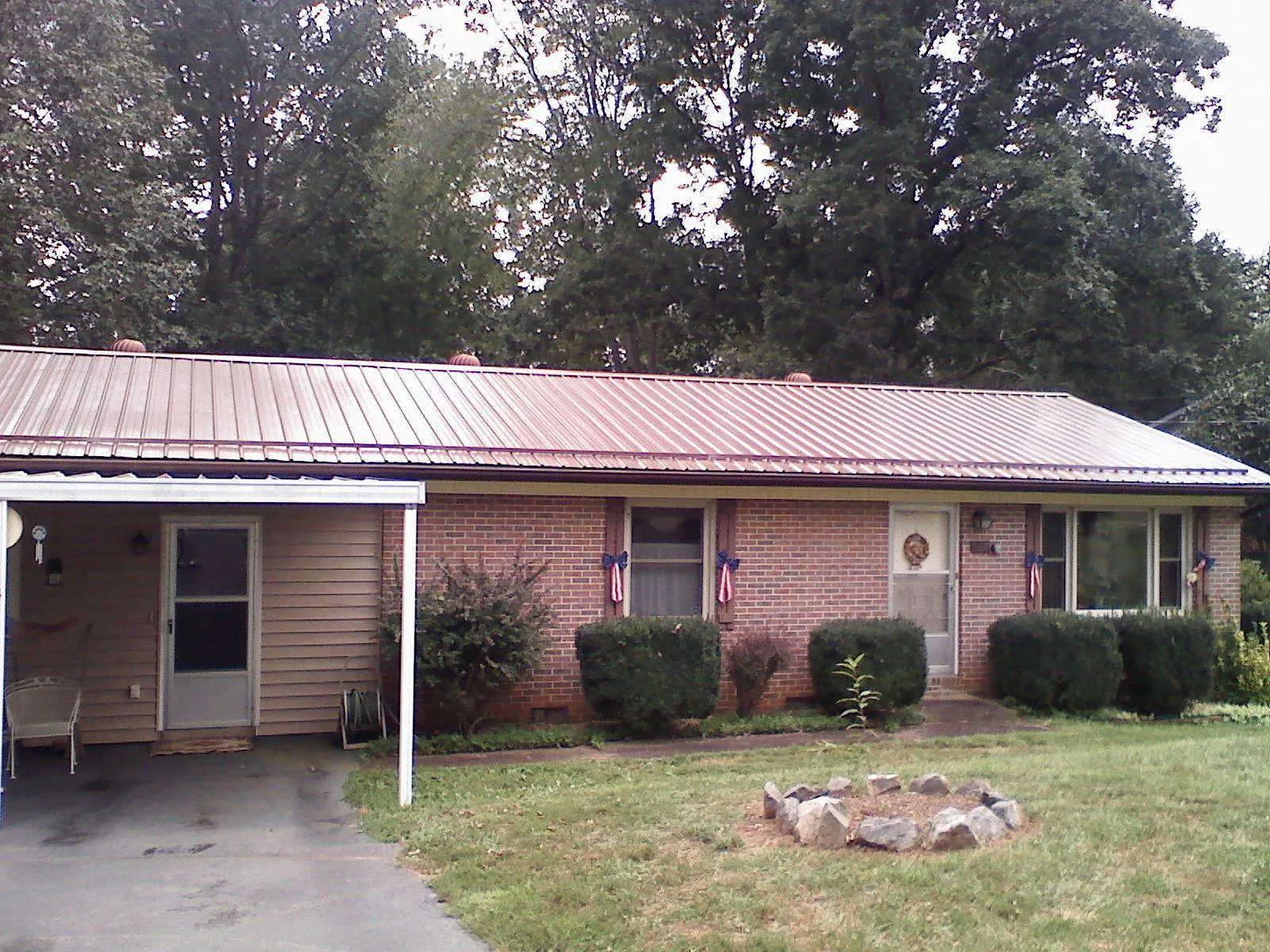 Bronze metal roof and carport on a brick ranch home — Roof Repair work by our crew in Belvue