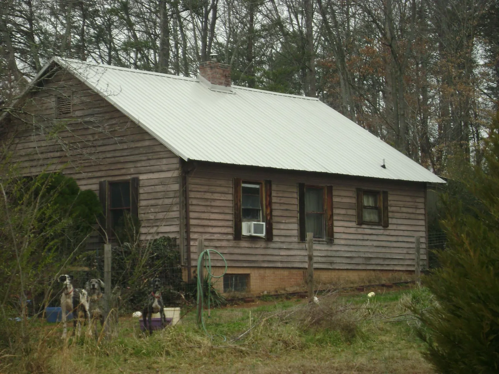 White metal roof on an old wood sided farmhouse, from a Metal Roof Installation job in Belvue